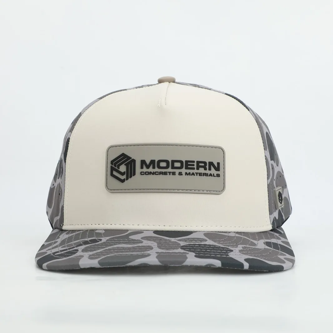 Molded PVC patch on a duck-camo Modern Concrete & Materials cap