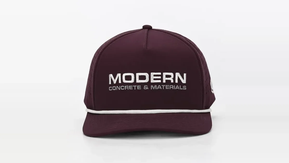 A maroon rope hat embroidered with the Modern Concrete & Materials logo