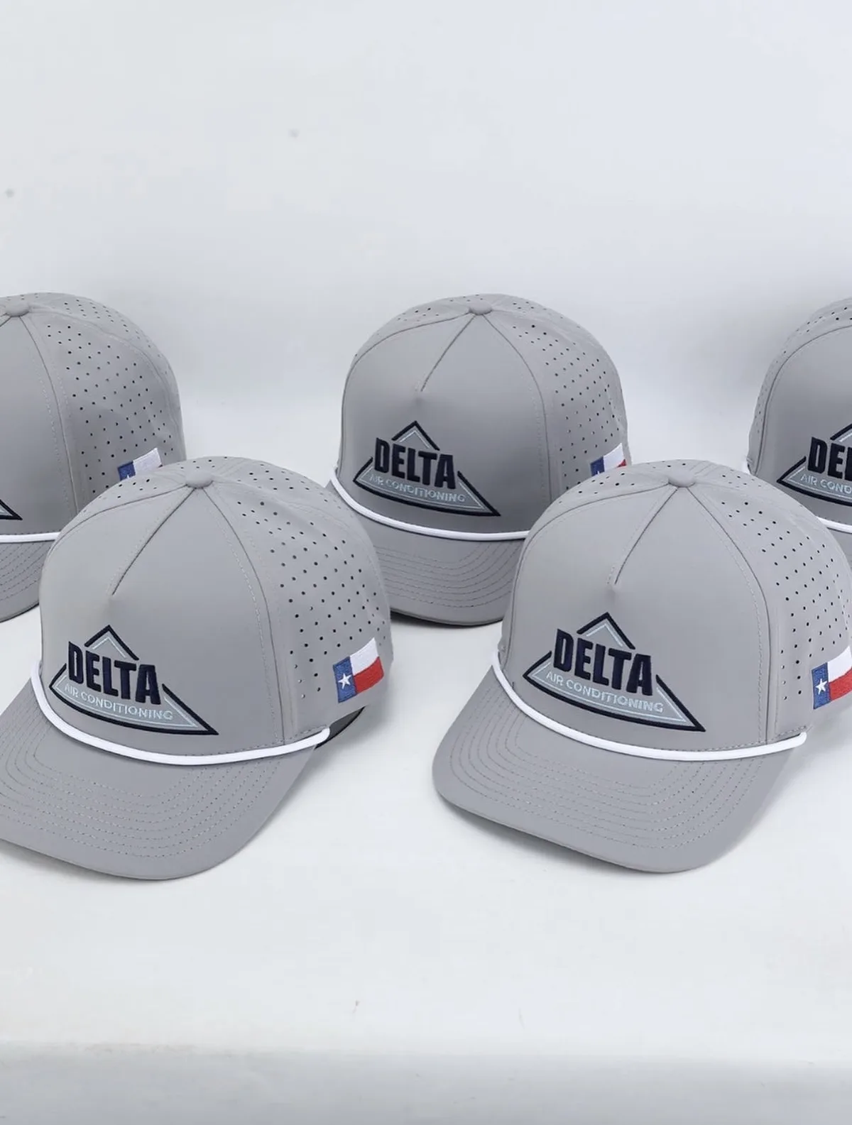 Grey Delta Air Conditioning caps with embroidered logo and Texas flag side patch