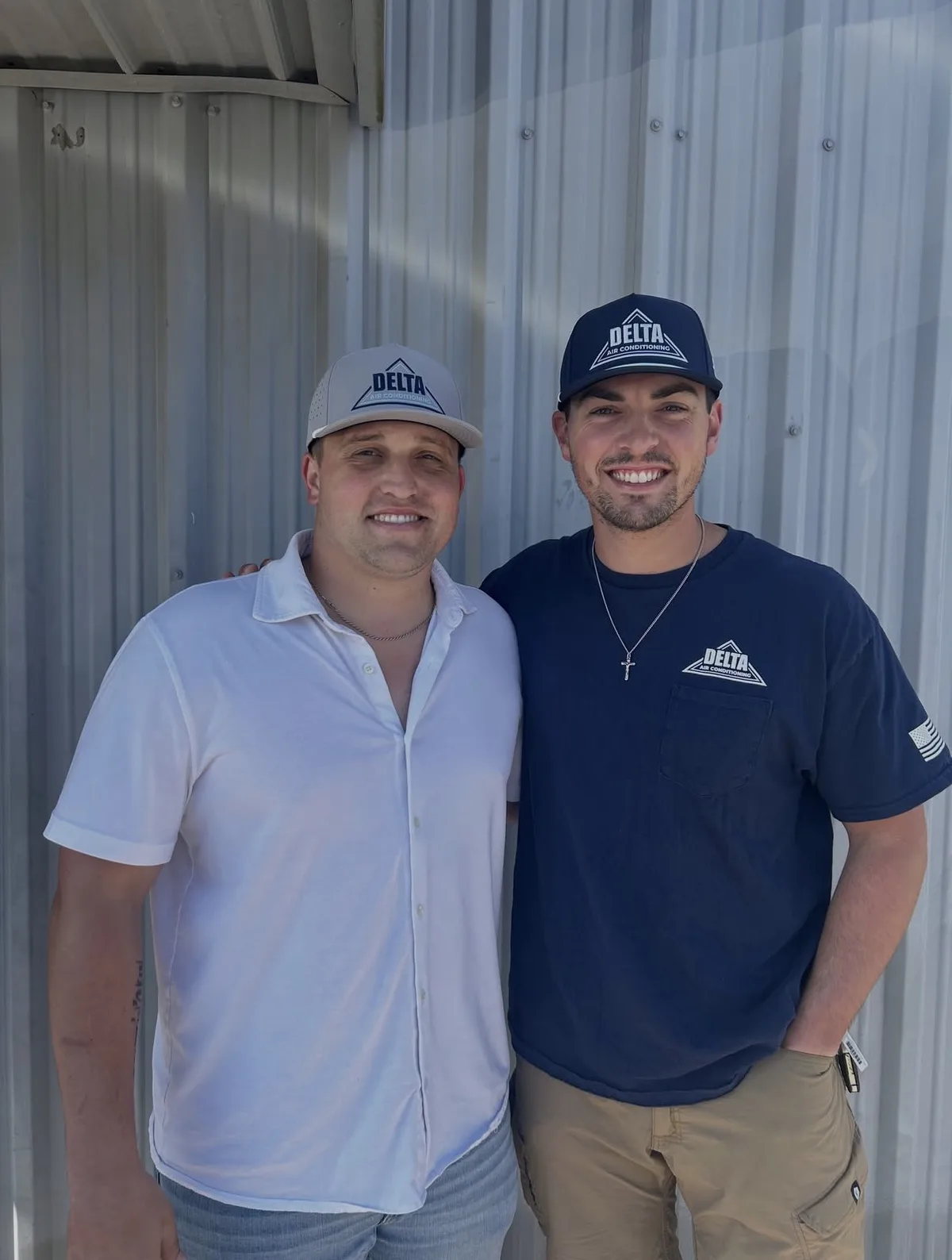 Two Delta Air Conditioning team members in grey and navy custom caps